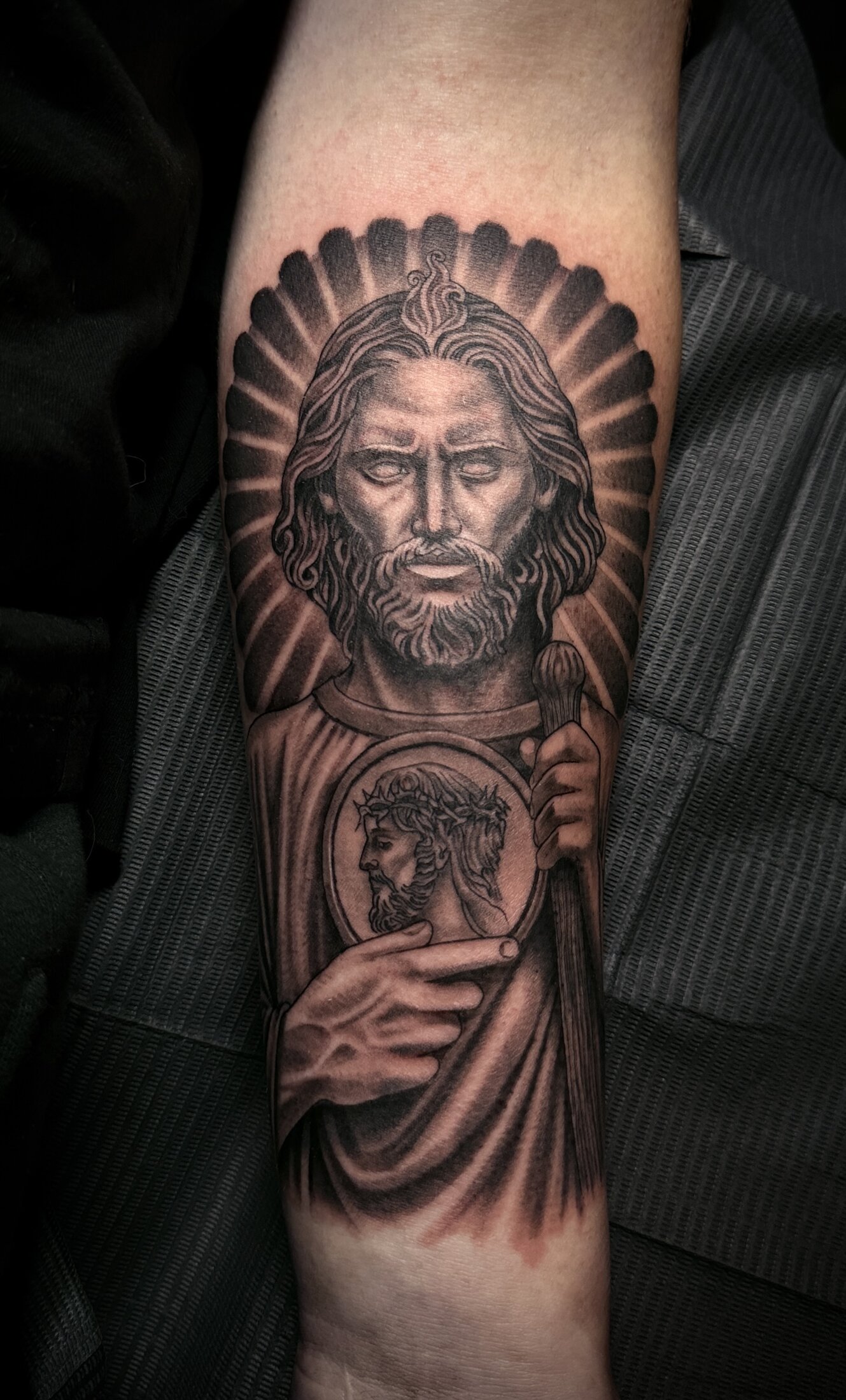 Black and grey realism religious portrait tattoo on a forearm