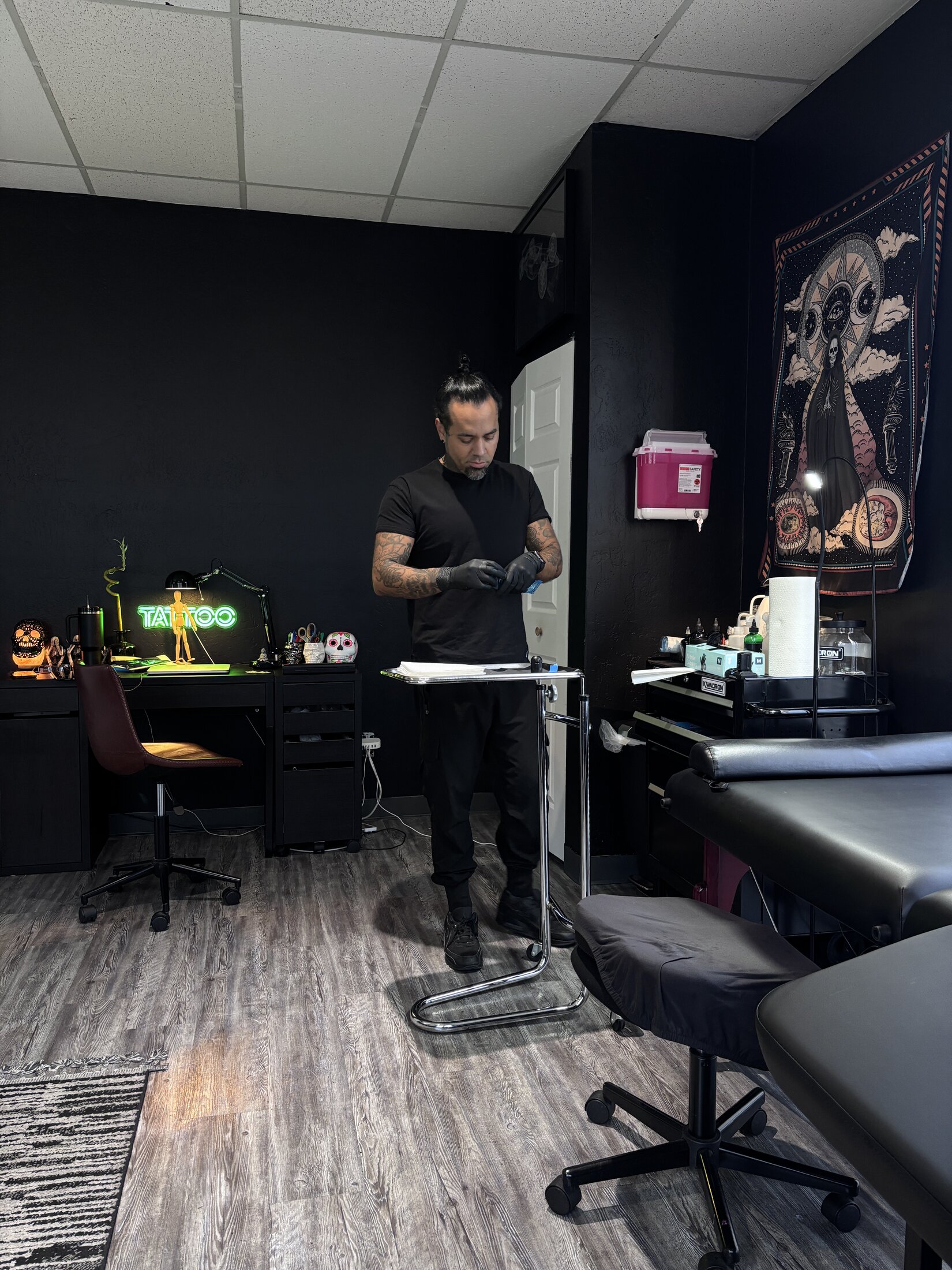 Private tattoo studio interior at night with a single artist station under one lamp